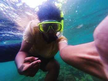 Portrait of man wearing scuba mask swimming underwater