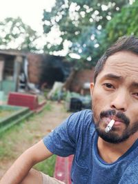 Portrait of young man smoking outdoors