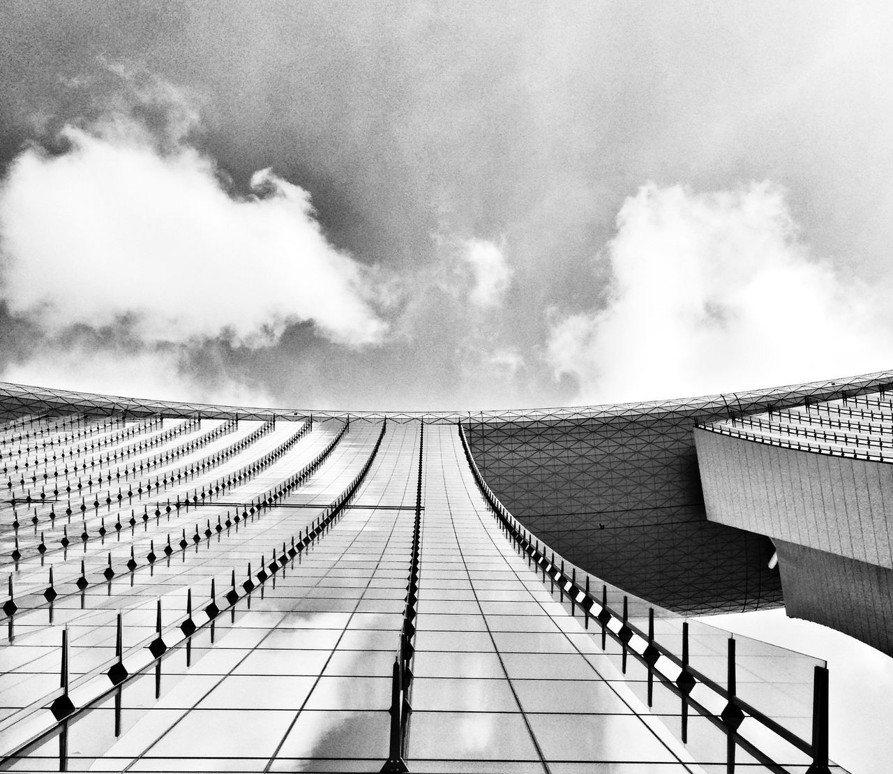 architecture, built structure, sky, building exterior, cloud - sky, cloudy, roof, diminishing perspective, low angle view, railing, the way forward, cloud, in a row, day, steps and staircases, outdoors, vanishing point, building, repetition, steps