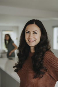 Portrait of smiling mature woman standing at home