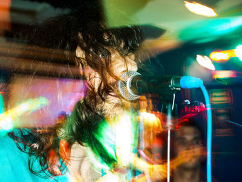 Portrait of woman with multi colored light trails at night