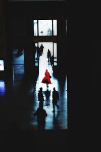 Silhouette people walking in dark room