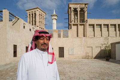 Portrait of woman standing against building