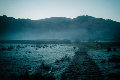 Mist path in a lake district valley with the hills in the background on a winter afternoon