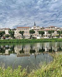 Reflection of buildings in lake against sky