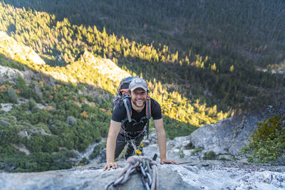 Man smiling while looking up jugging rope on east ledges el capitan