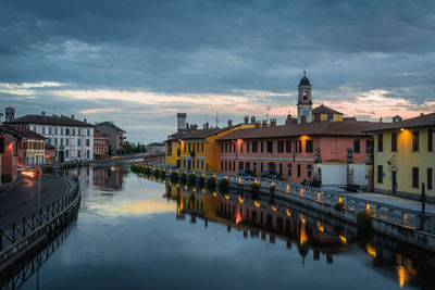 River amidst buildings in city against sky