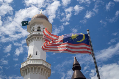 Low angle view of flag on building against sky