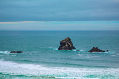 Scenic view of rocks in sea against sky