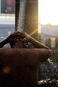 Close-up of man taking a shower