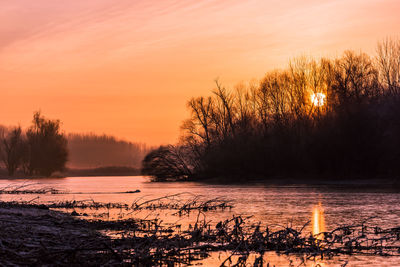 Scenic view of lake against romantic sky at sunset