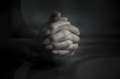 Close-up of human hand against black background