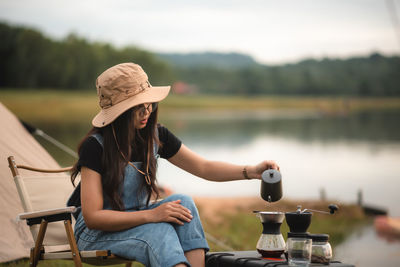 Midsection of woman sitting by lake