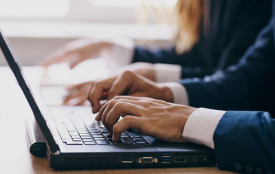 Midsection of woman using laptop