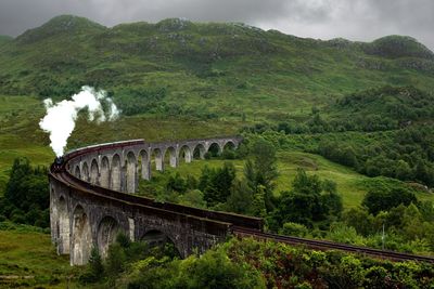 Scenic view of bridge over mountains against sky