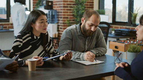 Portrait of woman using digital tablet while sitting at table