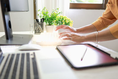 Midsection of man using laptop on table