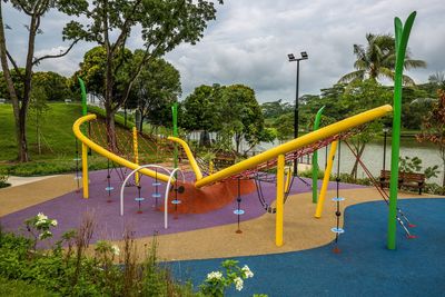 Empty playground in park against sky