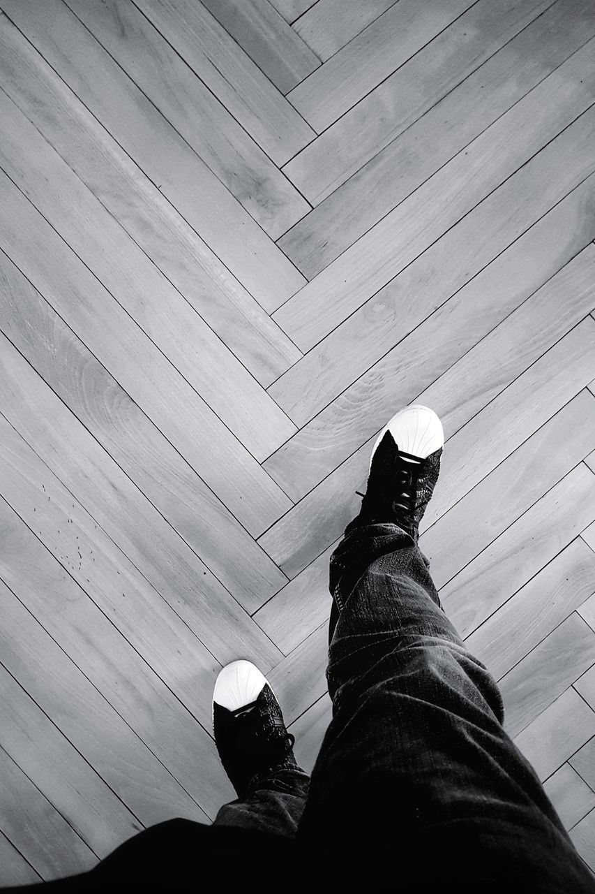 LOW SECTION OF MAN STANDING ON PATTERNED FLOOR