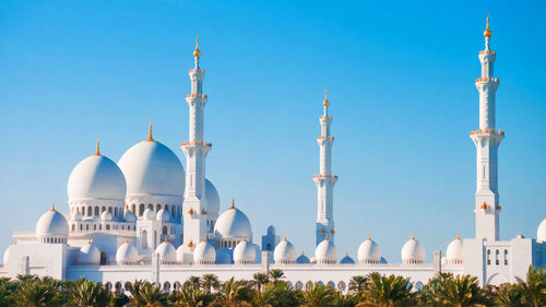 Panoramic view of buildings against clear blue sky