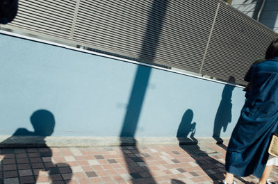 Close-up of woman and several silhouette of kids against street wall in tokyo japan