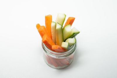 Close-up of chopped fruits in bowl against white background