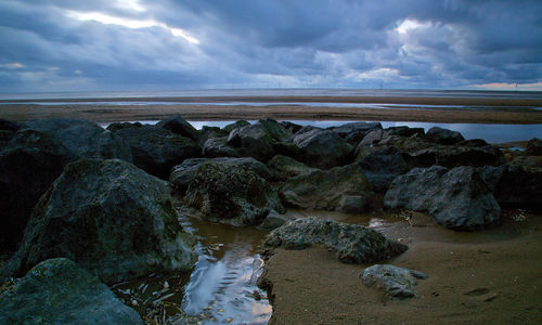 Rocks on beach against sky