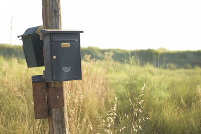 Close-up of mailbox on field against sky