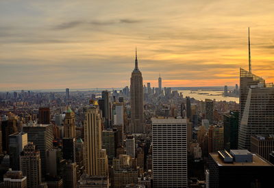 Modern buildings in city against cloudy sky during sunset