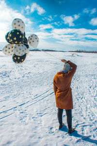 Rear view of man standing on snow covered land