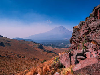 Scenic view of mountains against blue sky