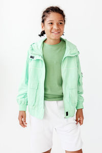 Portrait of young woman standing against white background