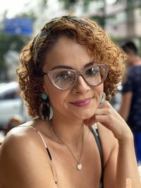 Portrait of smiling woman with curly hair wearing eyeglasses