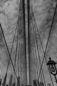 Low angle view of suspension bridge against sky