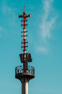 Low angle view of communications tower against blue sky