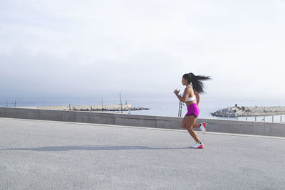 Image of a woman in sportswear jogging in the port. mixed race outdoor runner. active lifestyle 