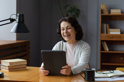 Young woman using phone while sitting at home