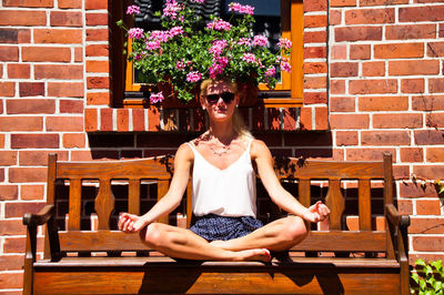 Portrait of young woman sitting on chair at table