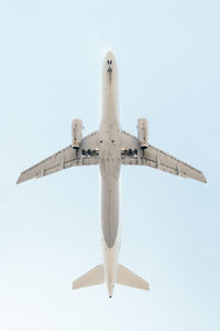 Low angle view of airplane flying against sky