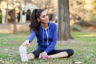 Young woman exercising on field