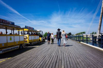 People walking on road against sky