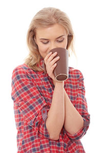 Young woman drinking coffee cup against white background