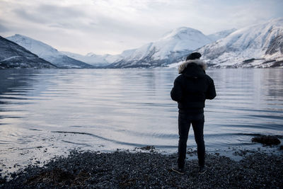 Rear view of man standing on shore