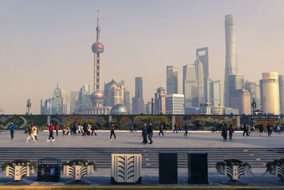 People walking on pedestrian walkway in city