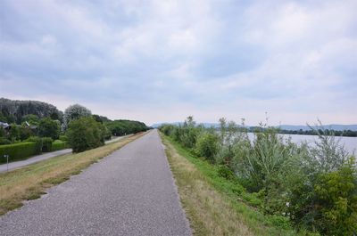 Road amidst trees against sky