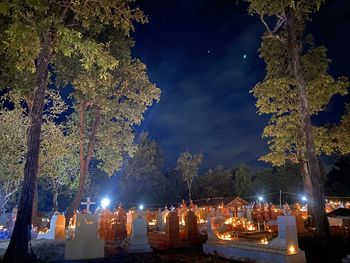 Illuminated cemetery against sky at night