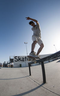 Man skateboarding on skateboard against sky