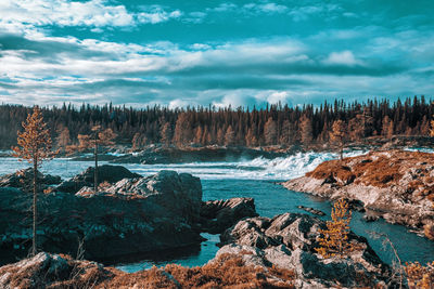 Panoramic view of rocks on shore against sky