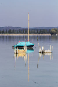 Sailboats moored in lake against sky