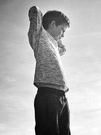 Side view of boy looking away against sky